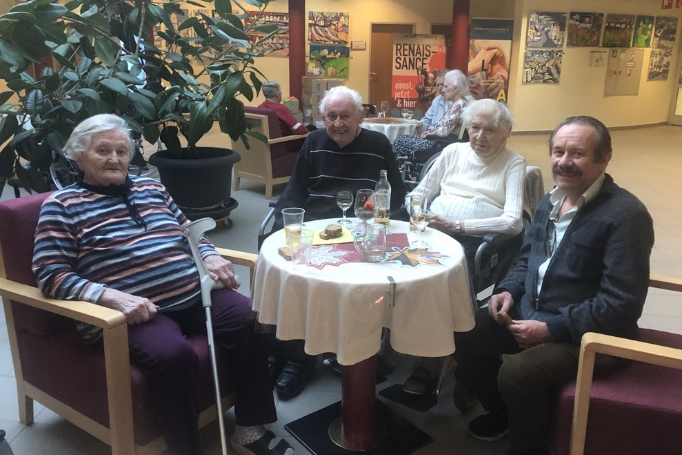 Damen und Männer trinken ein Glas Wein. 