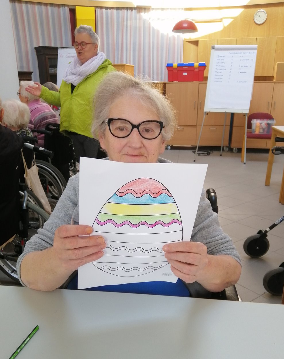 Eine Dame malt ein Osterbild.