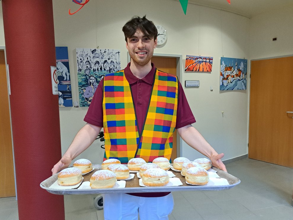 FSJ-Mitarbeiter bringt Krapfen. 