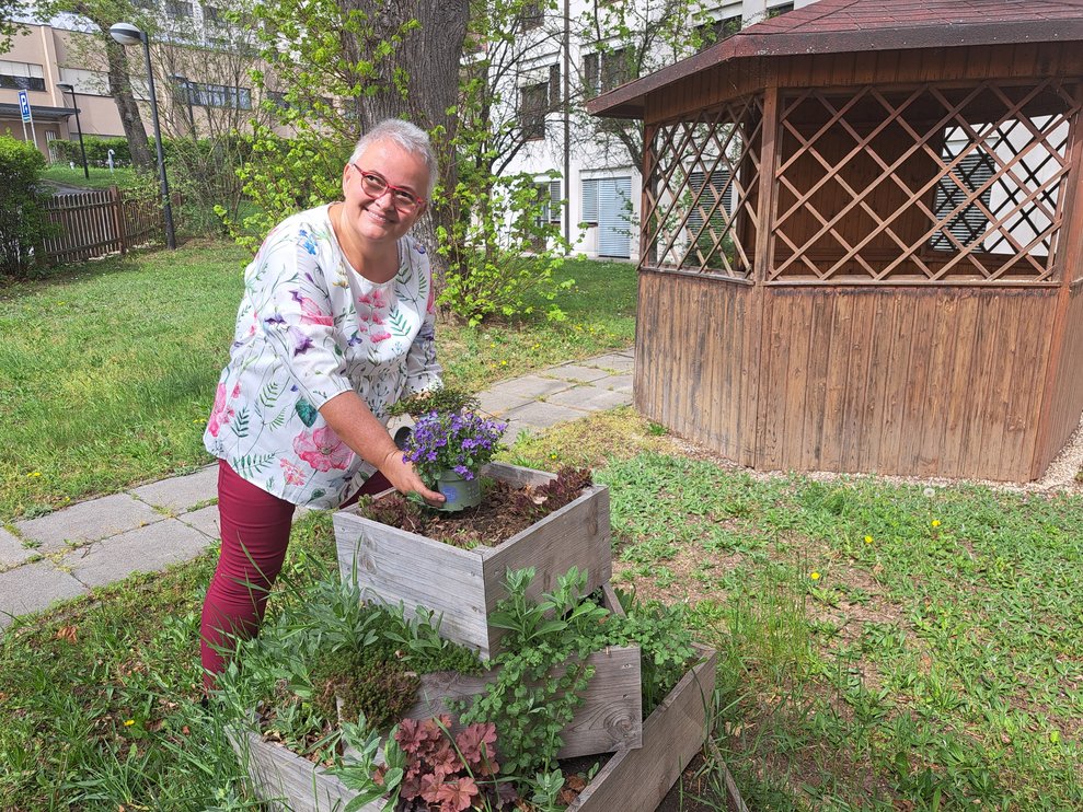 Eine Frau setzt Blumen in die Pyramide. 