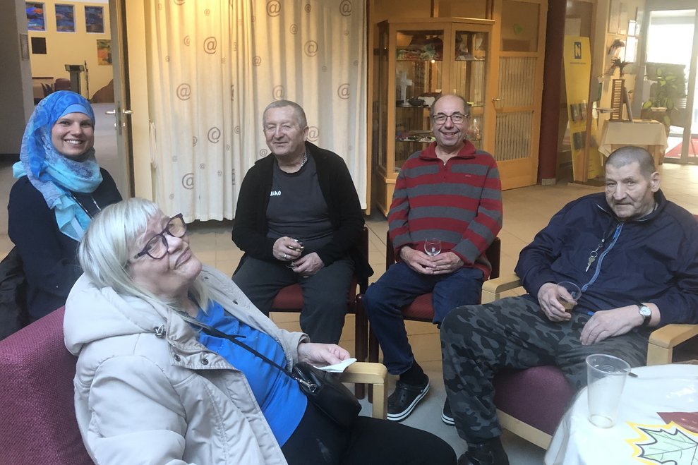 Männer und Damen sitzen in der Runde. 