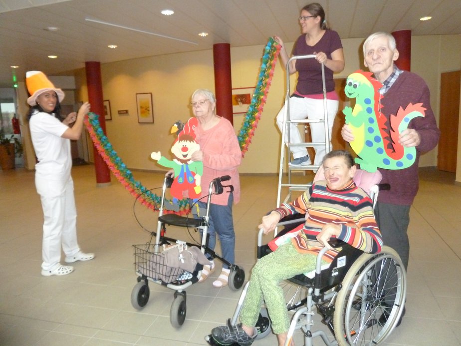 BewohnerInnen und BetreuerInnen halten Dekorationen.