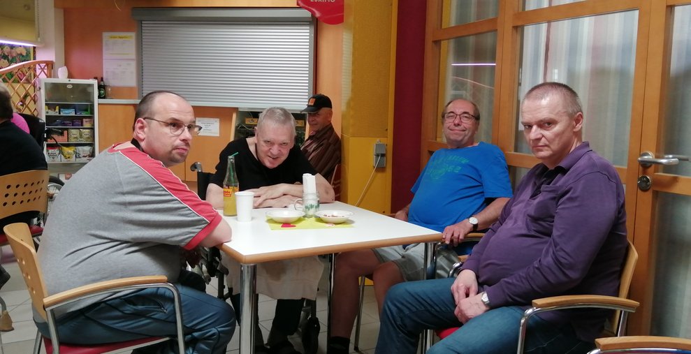 Vier Männer sitzen um einen Tisch. 